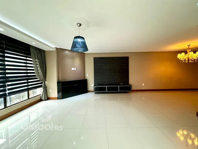 A sala de estar possui piso de cerâmica claro e paredes em tons terrosos.