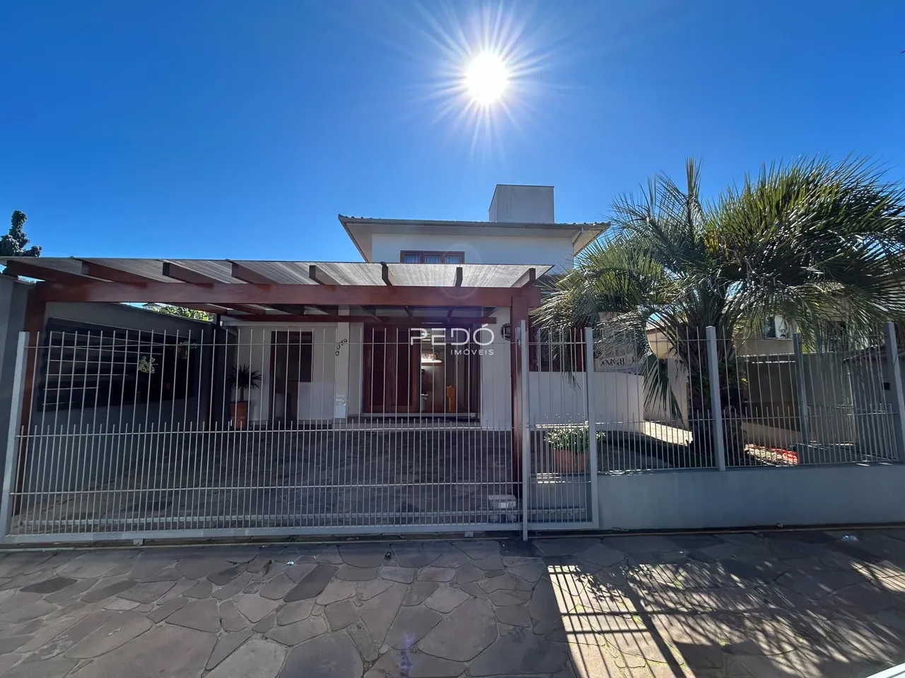 Fachada de uma residência em Lajeado, Brasil, com portão de ferro.