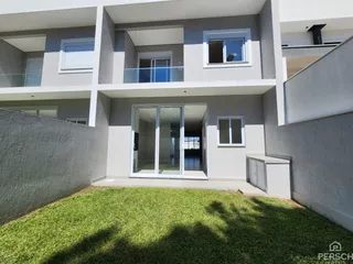 Fachada de um prédio residencial moderno com jardim na frente.