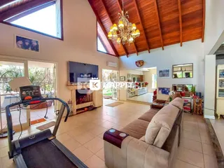 Sala de estar ampla com lareira e vista para o exterior.