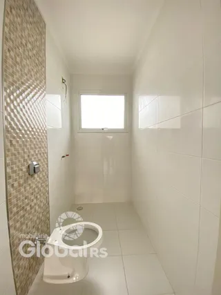 Foto de um banheiro com revestimento de azulejos brancos e marrons.