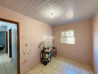 Quarto interno com parede rosa e piso de cerâmica em um imóvel no Brasil.