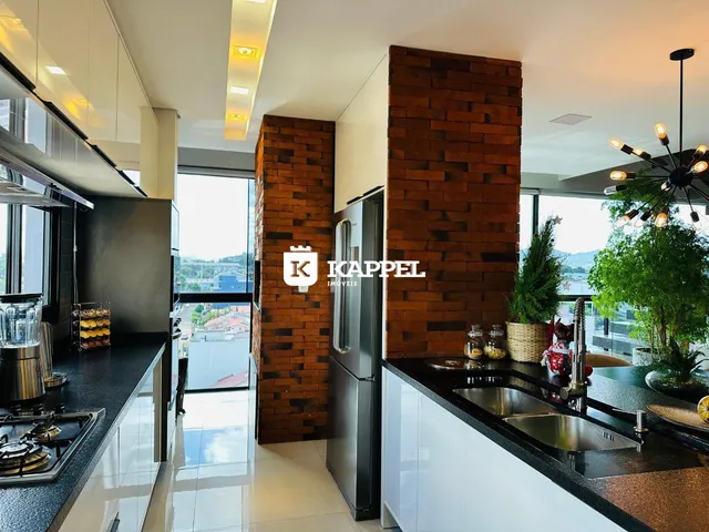 Cozinha moderna com bancadas escuras e vista para a paisagem externa.