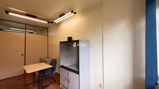 Interior de um corredor com piso de madeira e um armário branco.