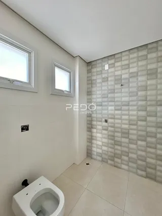 Foto de um ambiente interno com azulejos brancos e um vaso sanitário.