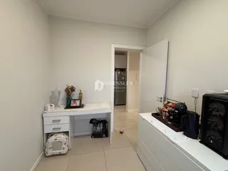 Vista interna de um ambiente com paredes brancas e piso claro.