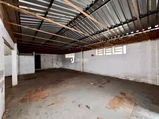 Imagem de um ambiente interno com estrutura de teto exposta.