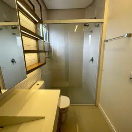 Hall de corredor interno com estrutura de madeira e portas de vidro.