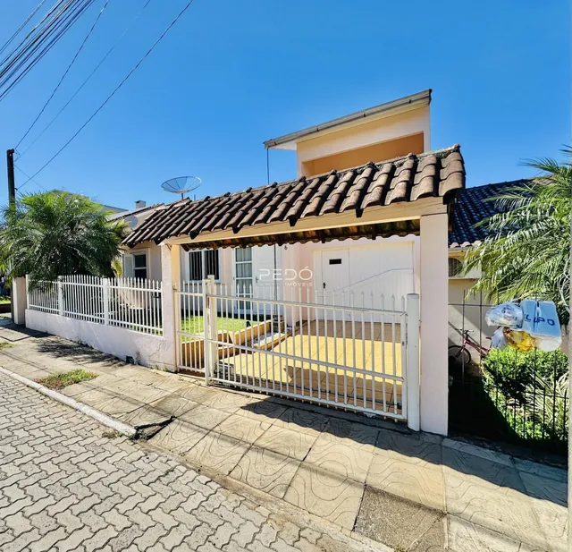 Fachada de uma residência com cerca branca e portão em Lajeado, Brasil.