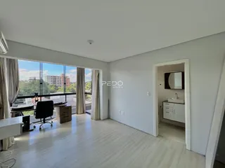 Sala de estar com grande janela e vista para a paisagem urbana.