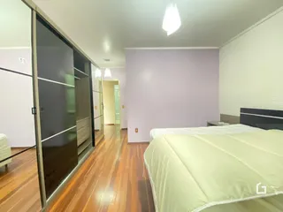 Quarto com piso de madeira e armário em Lajeado, Brasil.