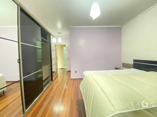 Quarto com piso de madeira e armário em Lajeado, Brasil.