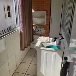 Corredor com piso de cerâmica branca.