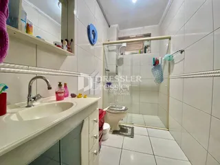 Foto de um banheiro com revestimento branco e pia.