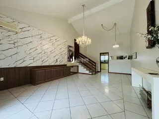 Ambiente interno de uma sala de estar com parede de mármore e piso de cerâmica clara.
