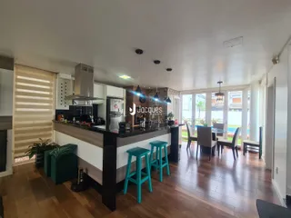 Uma cozinha moderna com piso de madeira e grandes janelas de vidro.