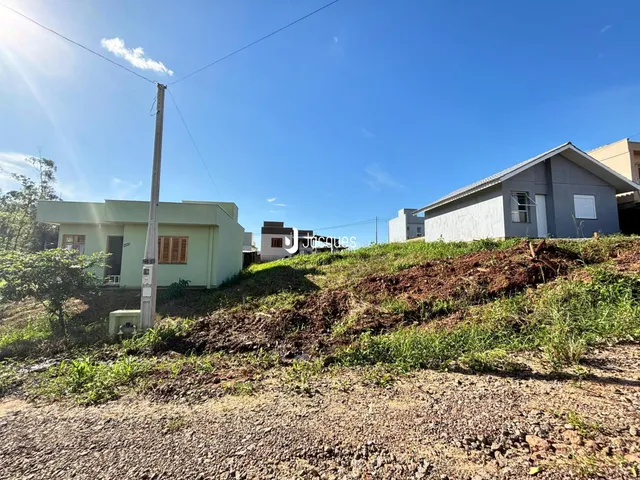 Vista externa de casas em Lajeado, Brasil, com terreno inclinado.