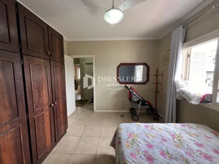 Quarto com armário de madeira e janela em um imóvel no Brasil.