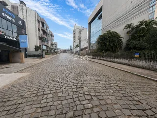 Vista da rua pavimentada com pedras no entorno de um edifício residencial em Lajeado.