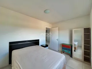 Quarto com cama e armário branco.