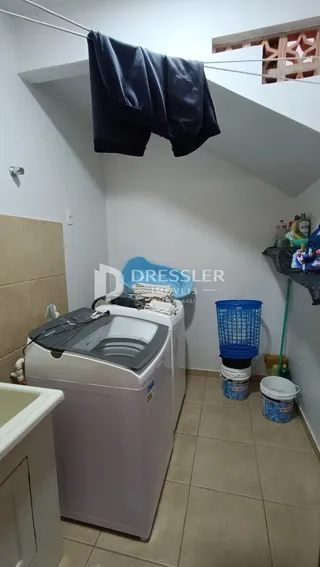 Foto de um interior com piso de cerâmica e um eletrodoméstico branco.