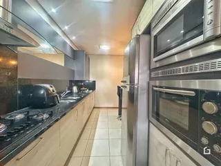 Cozinha moderna com armários e eletrodomésticos de aço inoxidável.