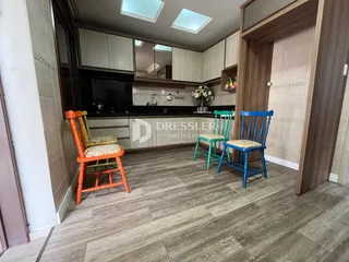 Foto de uma cozinha com armários e cadeiras coloridas em Lajeado.