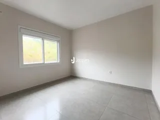 A sala apresenta paredes brancas e piso de cerâmica claro.