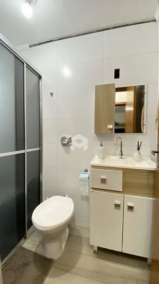 Interior de um banheiro moderno com revestimento branco.