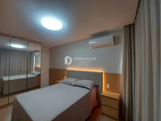Quarto com duas camas de solteiro e cortinas claras.