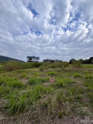 Vista externa de uma propriedade em Lajeado, Brasil, com vegetação alta no primeiro plano.