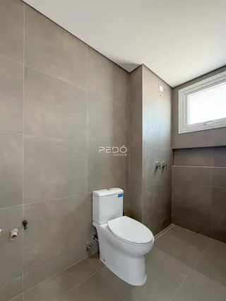 Foto de um banheiro com revestimento cerâmico e piso claro.