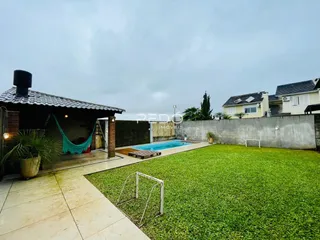 Vista externa de uma propriedade com piscina e jardim.