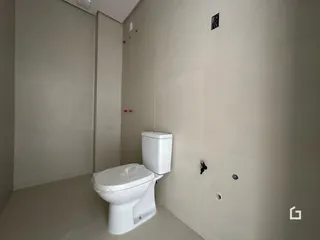 Foto de um banheiro interno com paredes brancas e vaso sanitário.
