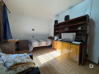 Quarto com cama e móveis de madeira no interior da residência.