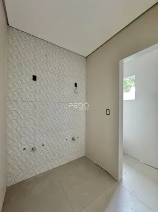 Parede com revestimento geométrico branco em um ambiente interno.
