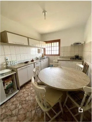 Foto de uma sala de jantar com mesa redonda de madeira.