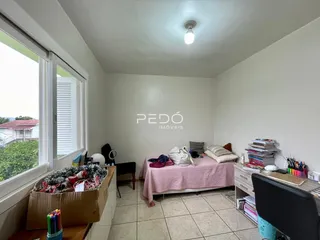 Quarto com janela e cama em ambiente interno.