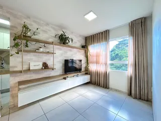 Sala de estar com paredes brancas e piso claro, com grande janela e cortinas.