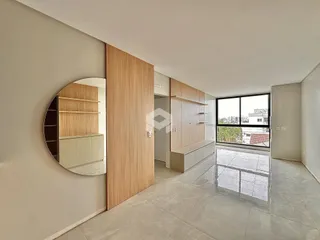 Ambiente interno de uma sala com piso de grande formato e parede de madeira clara.
