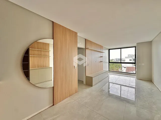 Ambiente interno de uma sala com piso de grande formato e parede de madeira clara.