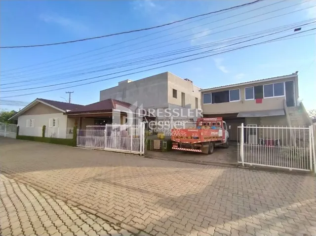 Fachada de uma residência em Lajeado, Brasil, com cerca e paisagismo.