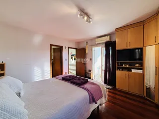 Quarto com cama e armários de madeira no interior da propriedade.