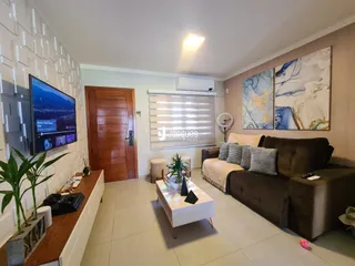 Sala de estar moderna com sofá e televisão em um imóvel no Brasil.
