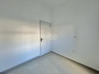 Interior de um ambiente com paredes brancas e uma porta branca.