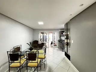 Sala de jantar com mesa e cadeiras em um imóvel no Brasil.