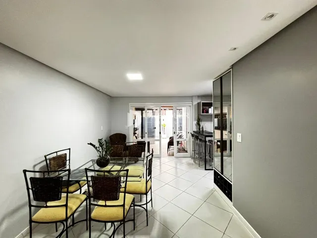 Sala de jantar com mesa e cadeiras em um imóvel no Brasil.