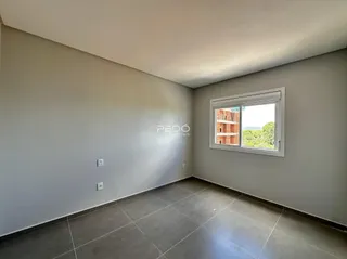 Interior de uma sala com paredes cinzas e piso de cerâmica.