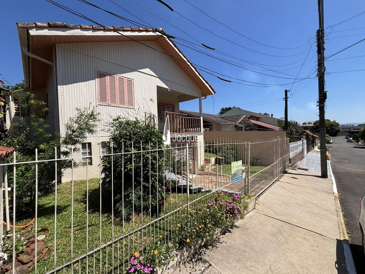 Fachada de uma casa em Lajeado, Brasil, com cerca e jardim frontal.