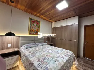 Quarto com cama grande e painel de madeira na cabeceira.